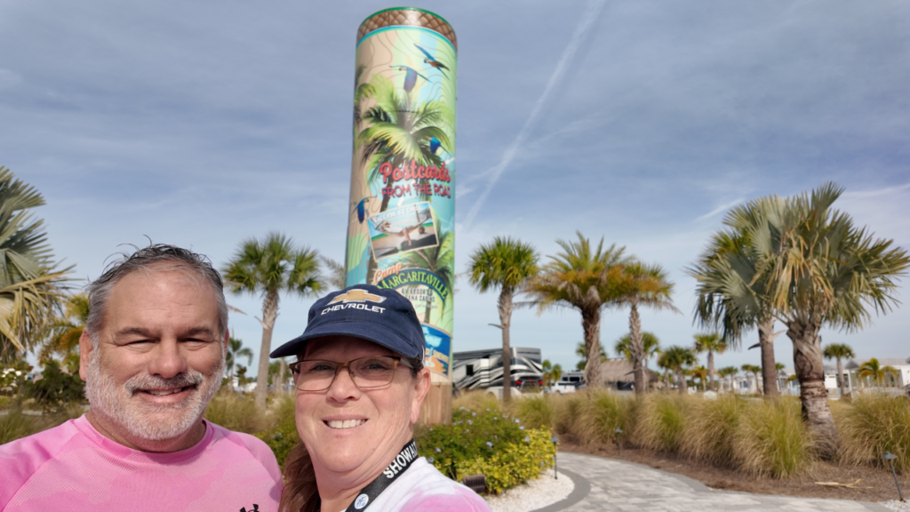 Lisa and Jimmy standing in front of Camp Margaritaville Auburndale sign at the entrance