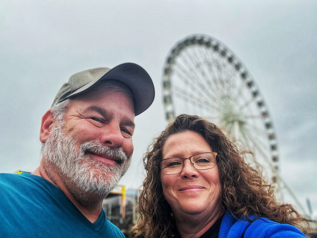 Jimmy and Lisa standing in front of a ferris wheel