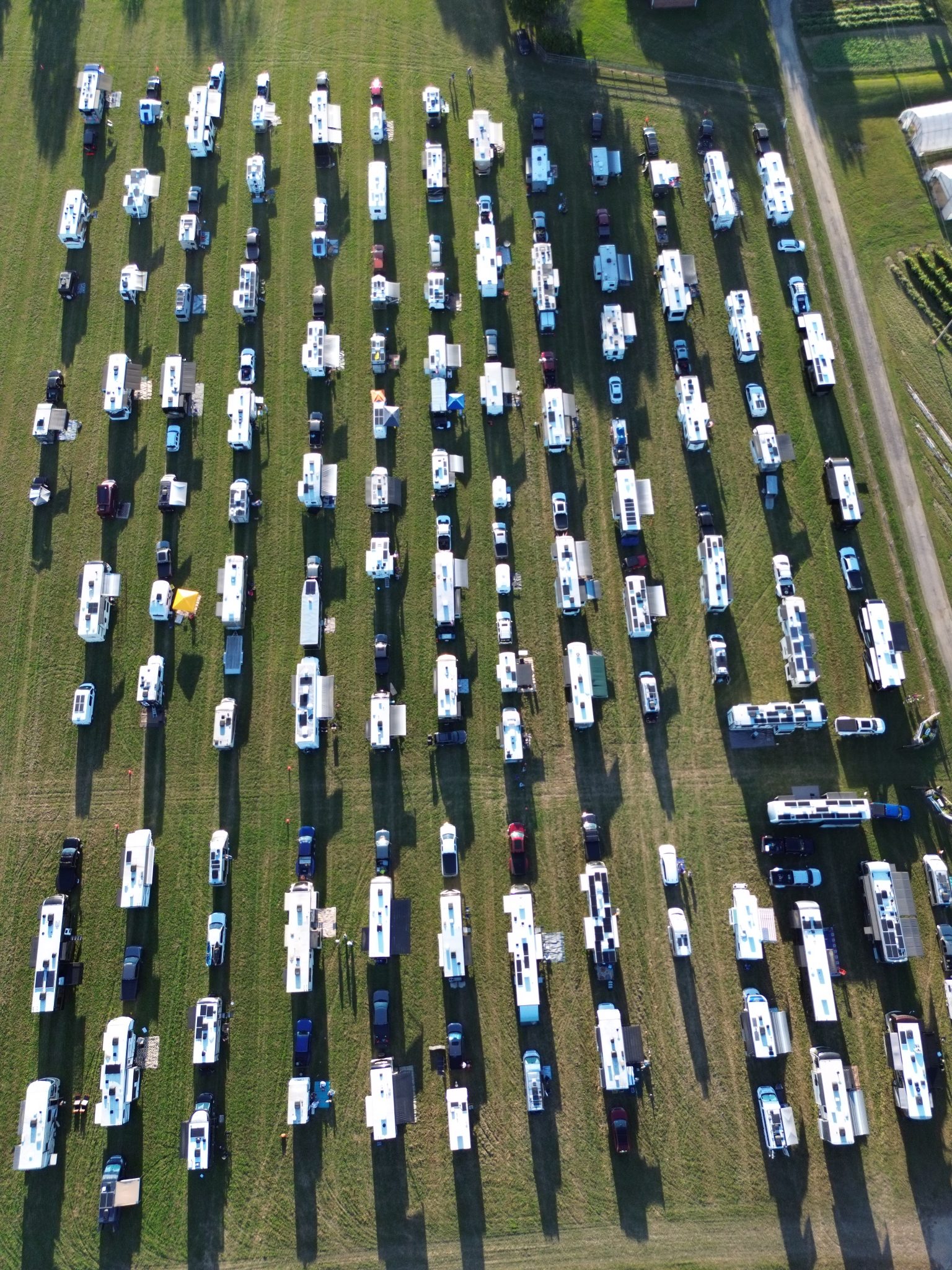 Drone view of over 100 RVs boondocking in a horse pasture at the 2026 FindUsCamping Barn Party