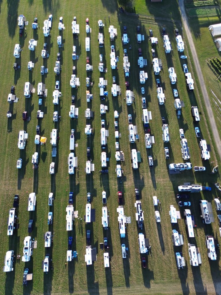 Drone view of over 100 RVs boondocking in a horse pasture at the 2026 FindUsCamping Barn Party