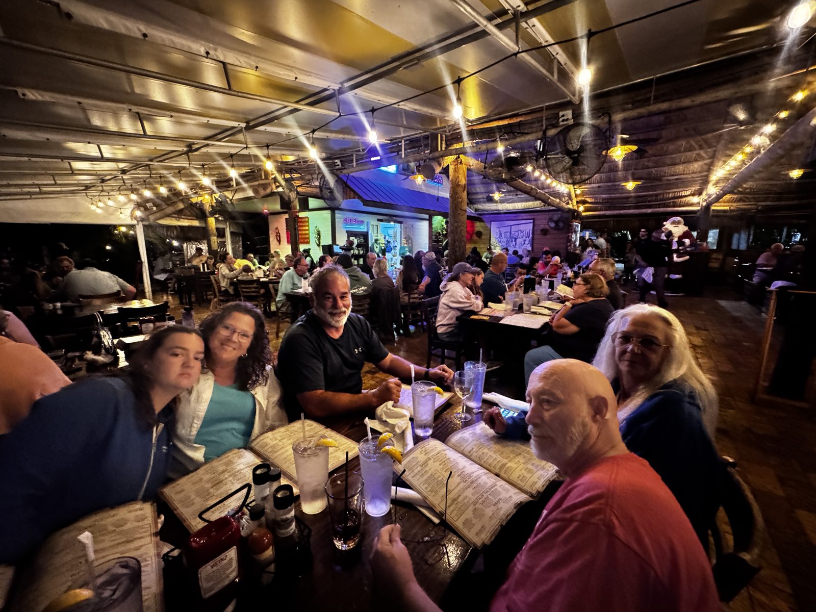 FindUsCamping Villagers sharing dinner together at a string-lit restaurant