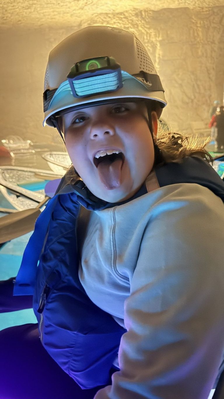 Young villager making a silly face while cave kayaking
