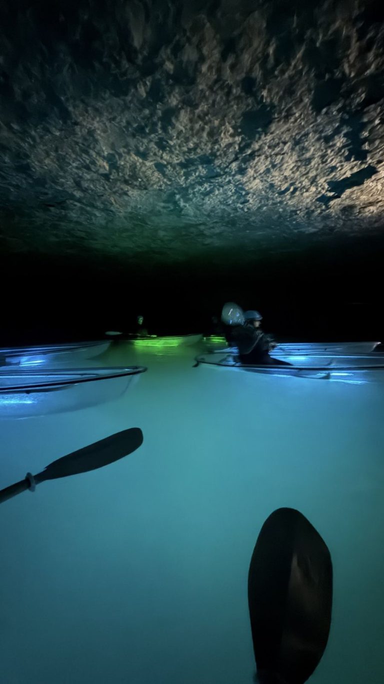 Glowing clear kayaks on an underground lake